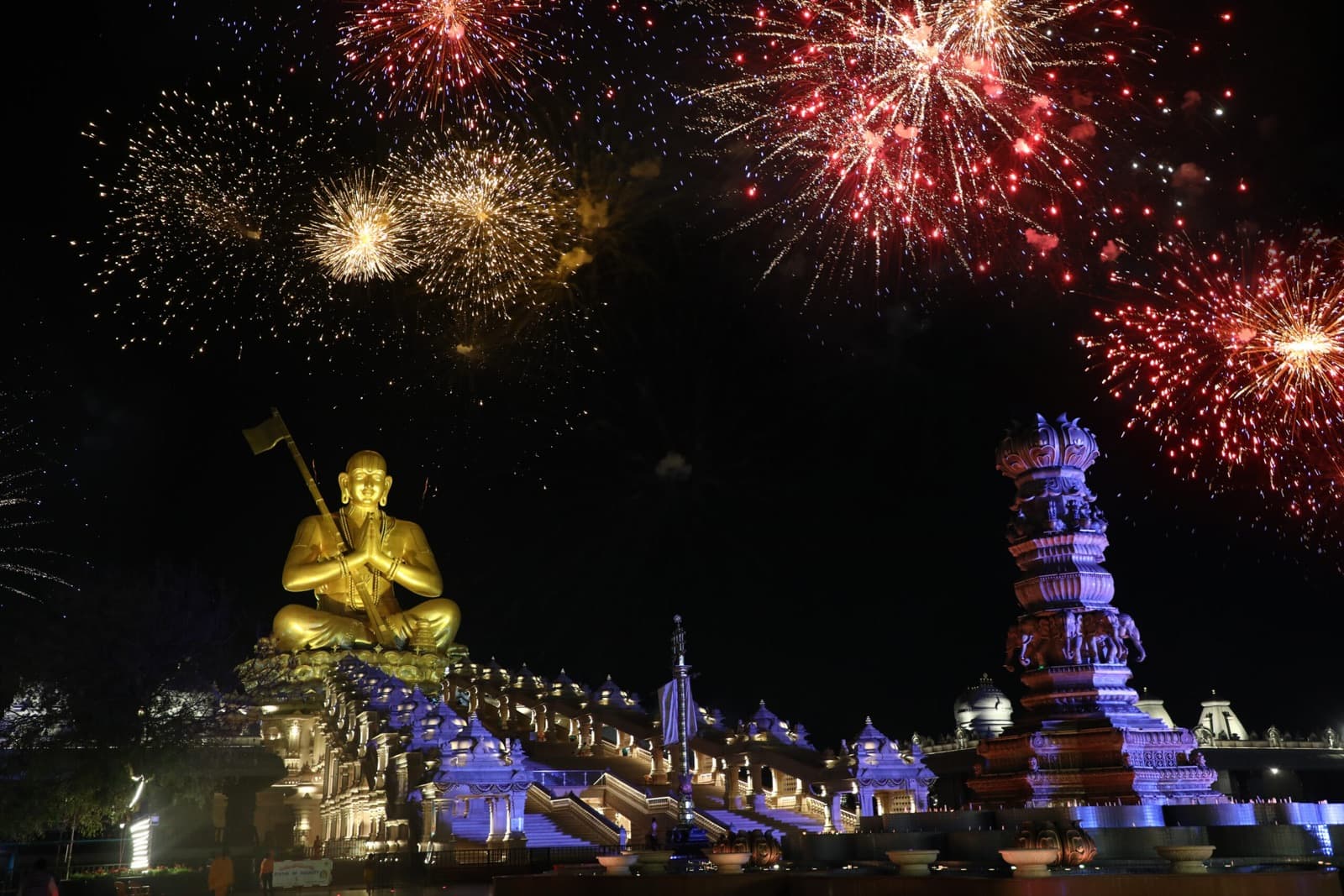 The illuminated Statue of Equality at Muchintal aglow under a night sky of fireworks
